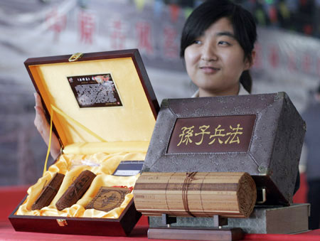 An exhibitor displays some books and souvenirs made of bamboo at Henan Tourist Commodities Exposition in Sanmenxia, a city of central China's Henan Province, April 16, 2009. About 600 companies participated in the exposition with over 2,000 types of commodities on show including Luoyang Tri-colored Pottery of Tang Dynasty and embroidery of ancient Kaifeng, etc. [Xinhua/Zhang Xiaoli]