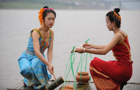 People perform a water-fetching ceremony by the Lancang River in Jinghong, Dai Autonomous Prefecture of Xishuangbanna, southwest China&apos;s Yunnan Province April 15, 2009. People celebrate the annual and traditional Water Splashing Festival, which signifies the visit of spring. [Xinhua]