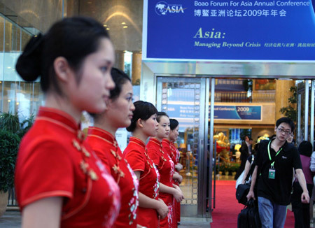 Girls stand ouside the Boao Forum for Asia (BFA) International Conference Center greeting guests attending the BFA Annual Conference 2009 in Boao, south China's Hainan Province, April 17, 2009. More than 1,600 officials, business leaders, intellectuals and journalists from around the globe gathered here for the three-day conference which kicked off here on Friday.