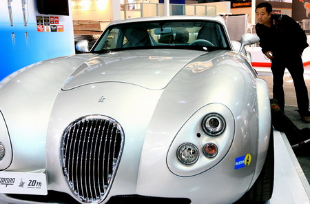 A worker takes a close look at a luxury sedan at the biennial Shanghai Auto Show which opens Monday to media and on Wednesday to the public, in Shanghai Sunday April 19, 2009. [Xinhua]