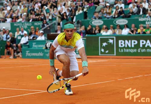 Spain's Rafael Nadal scoops out a winning shot. [CFP]