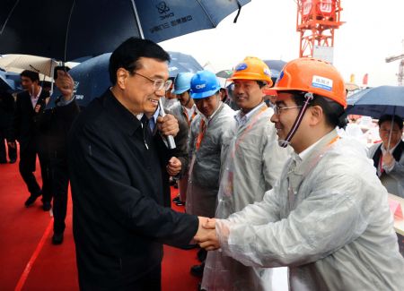 Chinese Vice Premier Li Keqiang (L, Front) shakes hands with an engineer during the opening construction ceremony of the first-phase project of the Sanmen Nuclear Power Plant in east China's Zhejiang Province. Li has urged more efforts to develop new energy to ensure the country's energy security and boost economy on Sunday.(Xinhua/Li Tao)