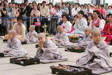 Novice monks take part in a ceremony after Buddhist monks cut their hair at the Jogye temple in Seoul April 19, 2009. A group of 9 boys entered the temple to experience life as monks for 18 days, ahead of celebrations for Buddha's birth date on May 2. [Xinhua/Reuters]