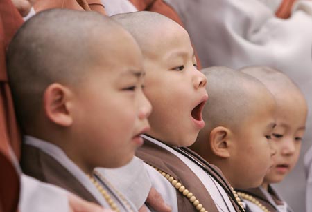 One of the novice monks yawns after a Buddhist monk cut his hair during a ceremony at the Jogye temple in Seoul April 19, 2009. A group of nine boys entered the temple to experience life as monks for 18 days, ahead of celebrations for Buddha's birth date on May 2. [Xinhua/Reuters]