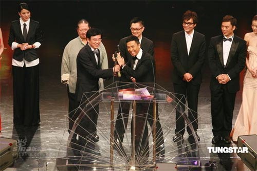 Hong Kong director Raymond Wong (left front) and actor Donnie Yen (right front) celebrate with the trophy after winning the Best Film award for movie 'Ip Man' at the Hong Kong Film Awards on Sunday, April 19, 2009.[Sina.com/TUNGSTAR]