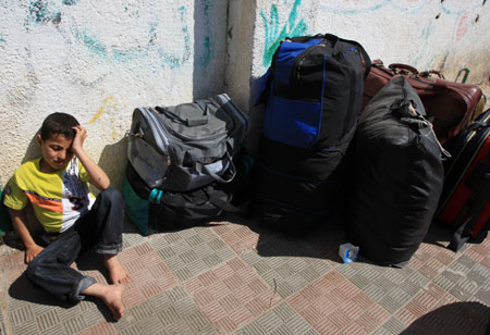  A Palestinian boy waits to enter Gaza from Egypt through the Rafah border crossing, in the southern Gaza Strip, April 19, 2009. [Wissam Nassar/Xinhua]