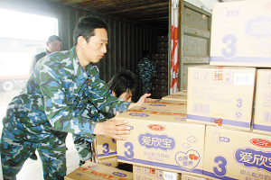 Workers are loading boxes of milk-powder products onto the truck on April 19. Hebei Sanyuan, the subsidiary company formed by Beijing-based Sanyuan Group to operate the assets of the failed Sanlu Group, held a ceremony on that day to launch its first batch of dairy products. [Yanzhao Evening News]