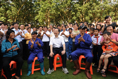 Chinese Premier Wen Jiabao (Front, C) talks with workers on a farm in Chengmai county, south China's Hainan Province, April 19, 2009. Wen was on an inspection tour on the island province from April 18 to 19.[Huang Jingwen/Xinhua]