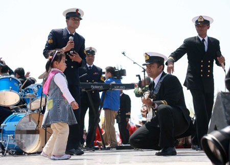 A little girl dances as members of Bangladeshi navy's military band perform during a performance in Qingdao, east China's Shandong Province, April 21, 2009.[Li Gang/Xinhua]