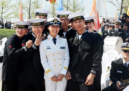 Members of South Korean navy's military band pose with an officer of Chinese People's Liberation Army Navy after a performance in Qingdao, east China's Shandong Province, April 21, 2009.[Li Ziheng/Xinhua]