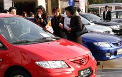 Shanghai residents pick cars at a store. The city is encouraging the purchase of automobiles with low emissions. [China Daily]