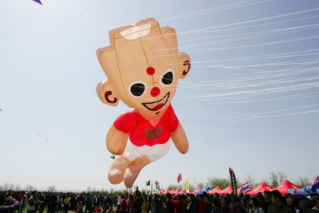 A kite in the shape of Taishan Boy, the official mascot of the 11th National Games, is flown to the sky at the 26th Weifang International Kite Festival in Weifang, east China's Shandong Province, on Tuesday, April 21, 2009. [Photo: CFP]