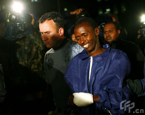 Abduhl Wali-i-Musi, accused of hijacking the Maersk Alabama and taking its captain Richard Phillips hostage, is led into a federal building in New York April 20, 2009. The sole surviving Somali pirate from the hijacking is being tried in New York and is scheduled to appear in court Tuesday morning. [tephen Chernin/GettyNorthAmerica/CFP]