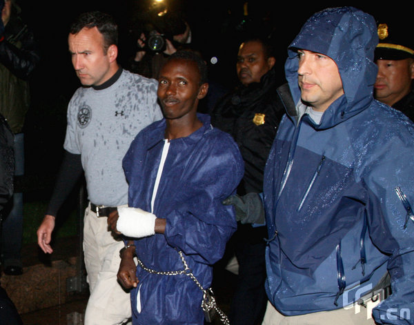 Abduhl Wali-i-Musi, accused of hijacking the Maersk Alabama and taking its captain Richard Phillips hostage, is led into a federal building in New York April 20, 2009. The sole surviving Somali pirate from the hijacking is being tried in New York and is scheduled to appear in court Tuesday morning. [tephen Chernin/GettyNorthAmerica/CFP] 