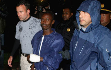 Abduhl Wali-i-Musi, accused of hijacking the Maersk Alabama and taking its captain Richard Phillips hostage, is led into a federal building in New York April 20, 2009. The sole surviving Somali pirate from the hijacking is being tried in New York and is scheduled to appear in court Tuesday morning. [tephen Chernin/GettyNorthAmerica/CFP]
