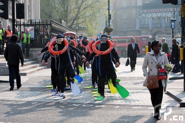 Londoners were 'Frog Mobbed' today as 30 frogmen dressed in full scuba diving gear took place at various locations throughout London and was being filmed for You Tube to promote Sky TV's Earth Day which is to highlight the awareness of rising sea levels. [Jeff Moore/CFP]