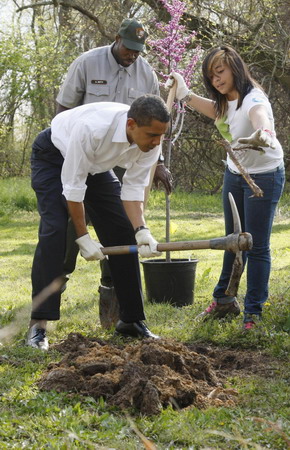 US President Barack Obama uses a backhoe as he plants Earth Day trees at Kenilworth Aquatic Gardens in Washington, April 21, 2009. [China Daily/Agencies]
