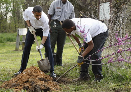 US President Barack Obama (L) plants a Earth Day tree at Kenilworth Aquatic Gardens in Washington, April 21, 2009. [China Daily/Agencies] 