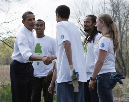 US President Barack Obama greets volunteers before planting Earth Day trees at Kenilworth Aquatic Gardens in Washington, April 21, 2009. [China Daily/Agencies]