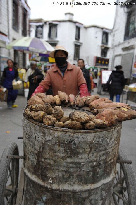 A woman sells baked sweet potatos in Bar-skor steet in Lhasa, southwest China's Tibet Autonomous Region. This photo is taken on early April this year. [Guo Xiaotian/China.org.cn]