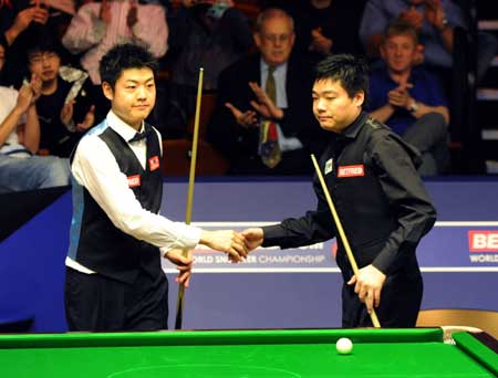 China's Ding Junhui (R) and his compatriot Liang Wenbo are seen during the first round match of 2009 World Snooker Championship in Sheffield, England, April 21, 2009. Ding finally pulled through to clinch the match 10-8. (Xinhua/Zeng Yi)