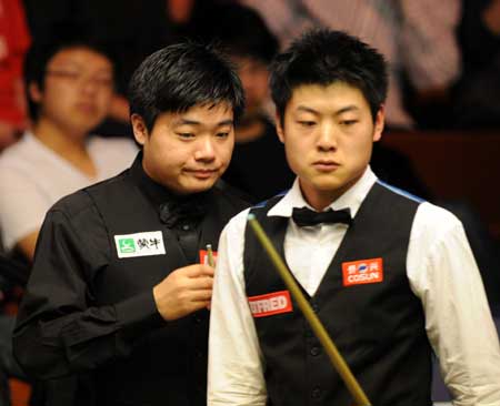 China's Ding Junhui (R) and his compatriot Liang Wenbo are seen during the first round match of 2009 World Snooker Championship in Sheffield, England, April 21, 2009. Ding finally pulled through to clinch the match 10-8. (Xinhua/Zeng Yi) 
