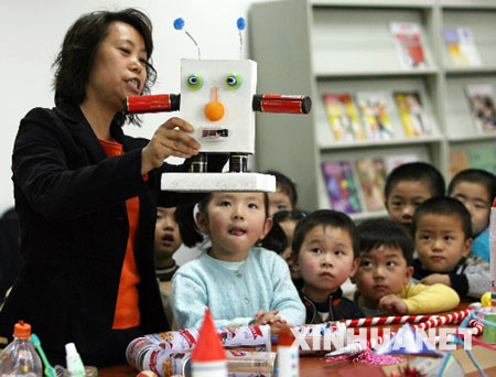 A teacher tells children how a robot has been made from waste materials in the Hongqiao Kindergarten of Suzhou, Jiangsu Province on April 20, 2009. The Earth Day, celebrated on every April 22, is a day designed to inspire people&apos;s awareness and appreciation for the Earth&apos;s environment.