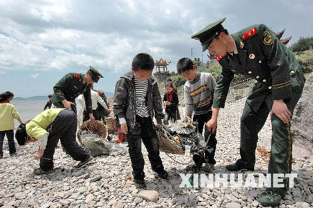 Soldiers and students collect garbage on a beach in Wenzhou, Zhejiang Province, on April 20, 2009. The Earth Day, celebrated on every April 22, is a day designed to inspire people&apos;s awareness and appreciation for the Earth&apos;s environment. 