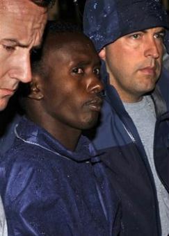 FBI agents escort the Somali pirate U.S. officials identified as Abduhl Wali-i-Musi into FBI headquarters in New York on Monday, April 20, 2009. Abduhl Wal-i-Musi is the sole surviving Somali pirate from the hostage-taking of commercial ship captain Richard Phillips.[Louis Lanzano/AP Photo] 