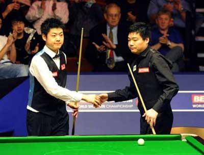 China's Ding Junhui (R) and his compatriot Liang Wenbo are seen during the first round match of 2009 World Snooker Championship in Sheffield, England, April 21, 2009. Ding finally pulled through to clinch the match 10-8. [Zeng Yi/Xinhua] 