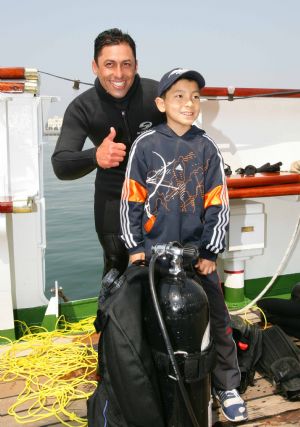 A little boy poses with a marine of the sailing ship ARM Cuauhtemoc of the Mexican Navy in Qingdao, east China's Shandong Province, April 22, 2009. Part of foreign naval vessels which came to attend the 60th anniversary celebration of Chinese People's Liberation Army Navy was open to public on Wednesday, attracting lots of visitors. [Zha Chunming/Xinhua]