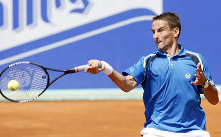 Tommy Robredo of Spain hits a return to Gaston Gaudio of Argentina during their match at the Barcelona Open tennis tournament April 22, 2009.[Xinhua/Reuters]