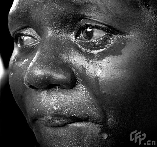 A woman weeps as the bodies of 12 children in Cabaret, Haiti, are laid onto a truck bed for the morgue September 7, 2008. [CFP]