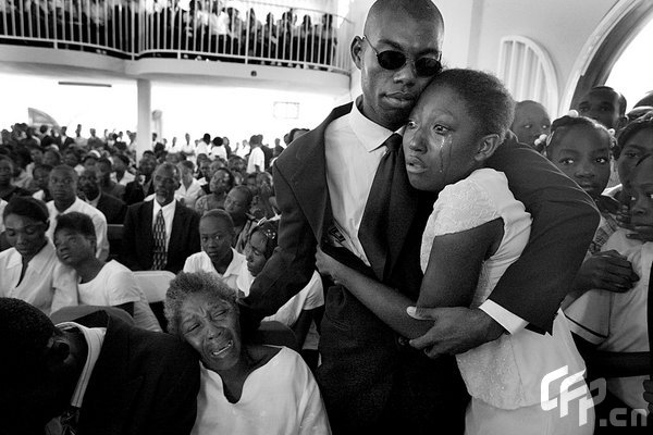 Fifteen-year-old Mardoshe Thelisma is comforted November 14, 2008, by 29-year-old Roman Jean Francois at the funeral of Mardoche's cousin Dieunana Thelisma, who was crushed to death when the three-story College La Promesse school collapsed in Petionville outside Port-au-Prince, Haiti.[CFP] 