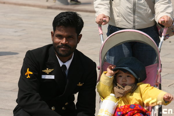 A little boy poses with a marine in Qingdao, east China's Shandong Province, April 22, 2009. Part of foreign naval vessels which came to attend the 60th anniversary celebration of Chinese People's Liberation Army Navy was open to public on Wednesday, attracting lots of visitors. [CFP]