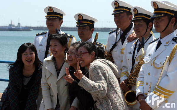 Four girls pose with marines in Qingdao, east China's Shandong Province, April 22, 2009. Part of foreign naval vessels which came to attend the 60th anniversary celebration of Chinese People's Liberation Army Navy was open to public on Wednesday, attracting lots of visitors. [CFP]