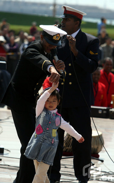 A little girl dances with a marine in Qingdao, east China's Shandong Province, April 22, 2009. Part of foreign naval vessels which came to attend the 60th anniversary celebration of Chinese People's Liberation Army Navy was open to public on Wednesday, attracting lots of visitors. [CFP]