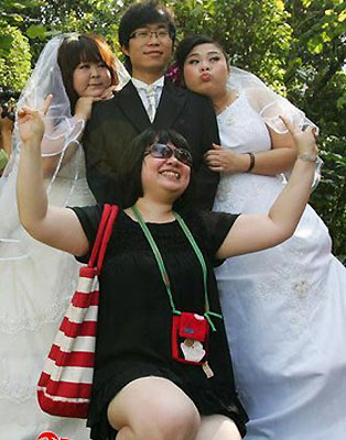 Girls pose for photos with one of the fiancés and their friend at their group engagement ceremony in Guangzhou on April 21, 2009. [sohu.com]