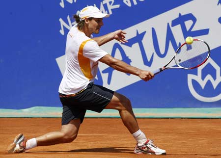 Gaston Gaudio of Argentina hits a return to Tommy Robredo of Spain during their match at the Barcelona Open tennis tournament April 22, 2009. (Xinhua/Reuters Photo) 