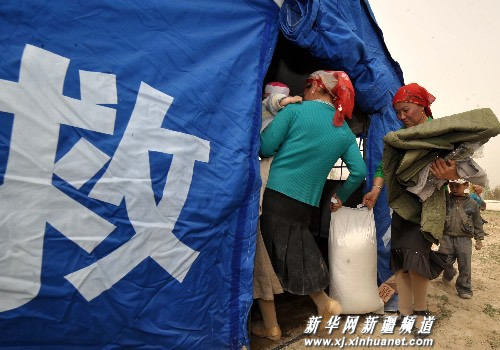 People receive disaster relief materials in the earthquake-hit Akqi County, Kizilsu Kirgiz Prefecture in Xinjiang Uygur Autonomous Region on April 21, 2009.