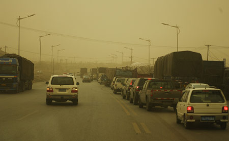 Vehicles run in sandstorm on a highway in Inner Mongolia Autonomous Region, north China, April 23, 2009. The heavy sandstorm caused inconvenience for local production and traffic on Thursday. (Xinhua Photo) 