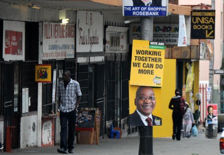 People pass by posters of presidential candidates in Johannesburg, April 21, 2009. South Africa will hold the general elections on Wednesday. [Xu Suhui/Xinhua]