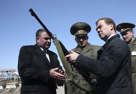 Russia's President Dmitry Medvedev (R) holds a rifle during a visit to the General Vasily Margelov Paratrooper School in Ryazan April 22, 2009. Also pictured are Russian Defense Minister Anatoly Serdyukov (L) and the head of the school, Vladimir Lugovoi (2nd L).[Xinhua/Reuters]