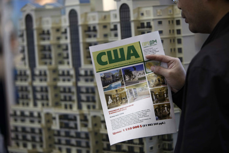 A visitor looks at an advertisement during the opening day of a real estate fair in Moscow April 22, 2009. Real estate companies from nearly 20 countries attended the fair but few visitors were attracted here, probably because of the ongoing global financial crisis. [Xinhua]