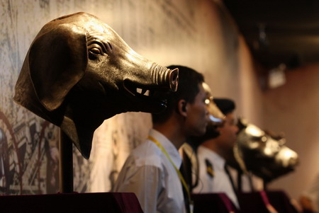 Security guards stand by the four Old Summer Palace bronze sculptures which will be displayed from April 25 to May 5, in Foshan, south China's Guangdong province, Wednesday April 22, 2009. [CFP]