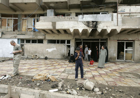Residents gather at the site of a suicide bombing in Baghdad April 23, 2009. A suicide bomber wearing a vest stuffed with explosives blew himself up in a group of police distributing relief supplies in Baghdad on Thursday, killing at least 28 people and wounding 50, Iraqi police said. [Xinhua/Reuters]