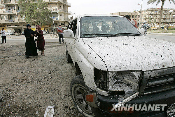Residents gather at the site of a suicide bombing in Baghdad April 23, 2009. A suicide bomber wearing a vest stuffed with explosives blew himself up in a group of police distributing relief supplies in Baghdad on Thursday, killing at least 28 people and wounding 50, Iraqi police said. [Xinhua] 