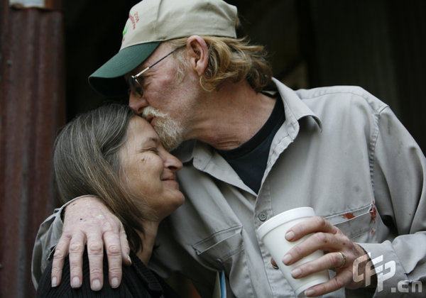  Bob Lupton kisses his wife Connie as they wait at the House of Blues Red Cross center after evacuating their home in North Myrtle Beach, South Carolina, on Thursday, April 23, 2009. [Logan Mock-Bunting/GettyNorthAmerica/CFP]