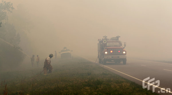 Firefighters work to keep a fire down after it crossed Highway 22 near North Myrtle Beach, South Carolina, on Thursday, April 23, 2009.[Logan Mock-Bunting/GettyNorthAmerica/CFP]