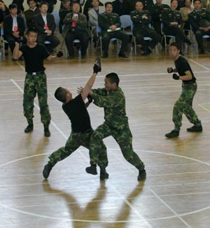 Chinese students from Tianjin University of Science and Technology stage combat skills at a commemorative ceremony in north China's coastal city of Tianjin, April 22, 2009. The university has been joining hands with Beijing Military Area Command of the Chinese People's Liberation Army (PLA) for five years to educate high-quality national defense officers for the PLA. [Li Xiang/Xinhua]